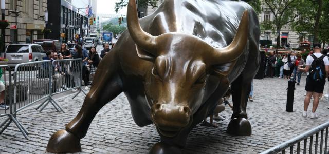 a statue of a bull on a brick street by Harri P courtesy of Unsplash.